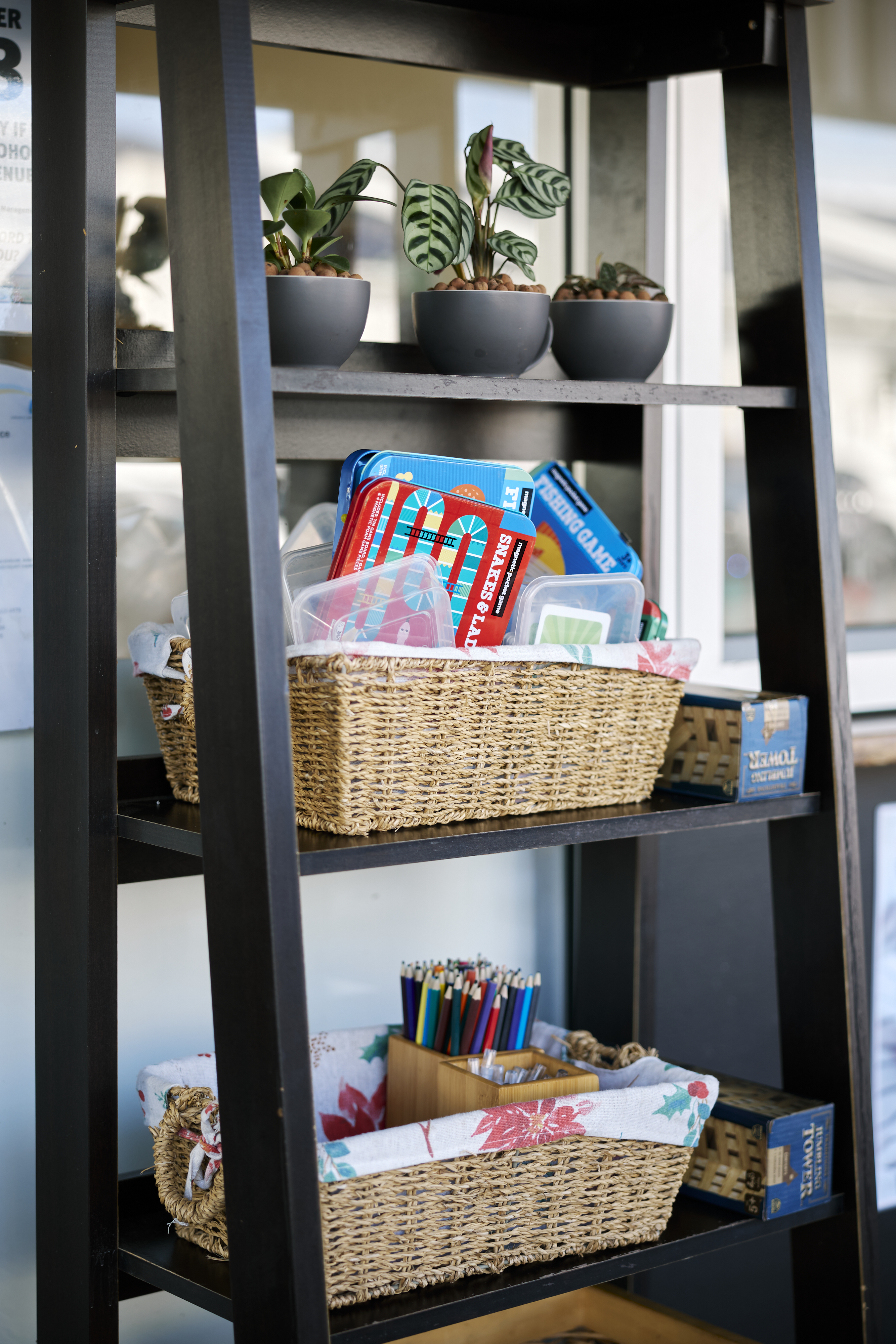 Kids corner at Mickle Pickle — shelves stocked with board games, colouring pencils and activity packs