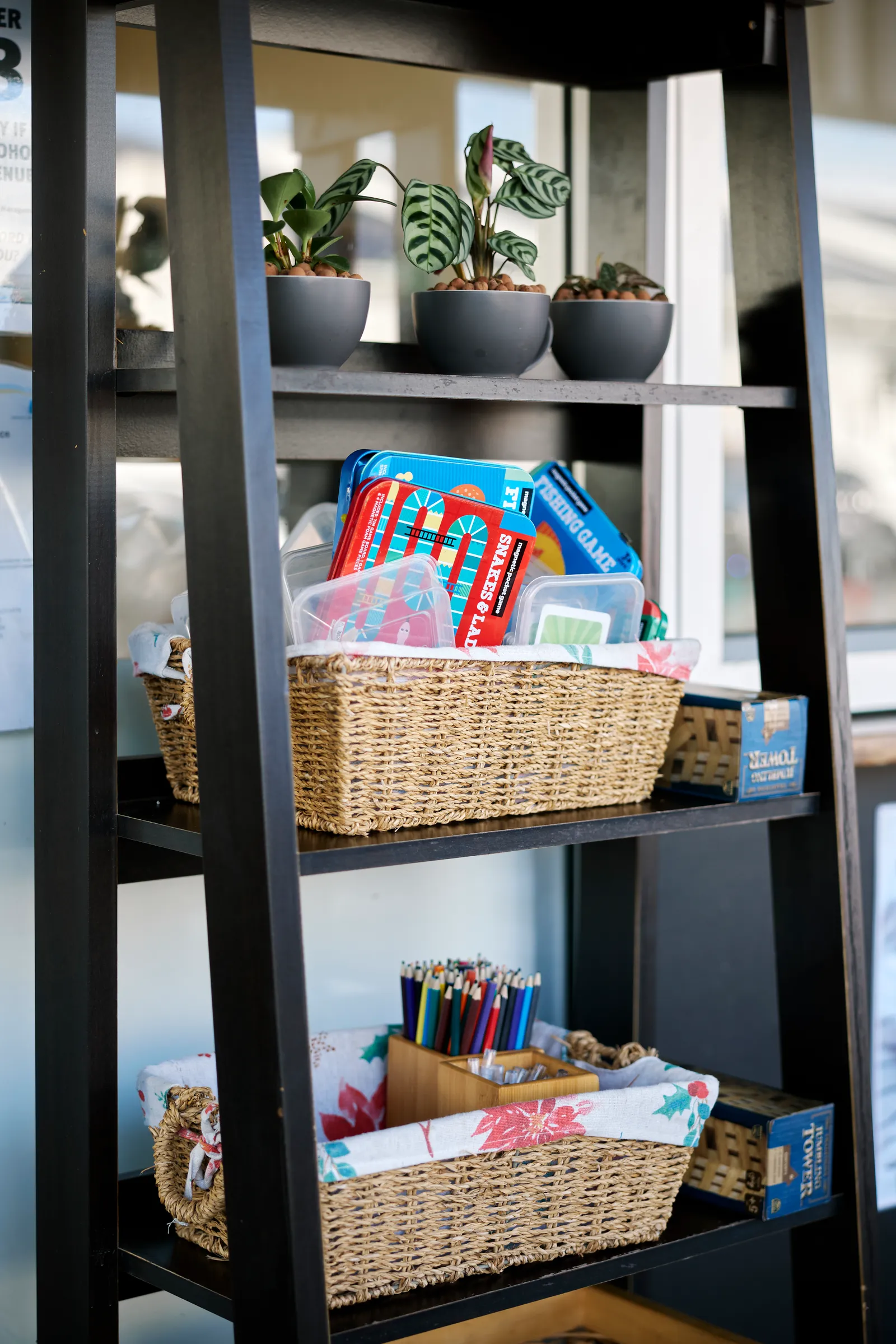 Kids corner at Mickle Pickle — shelves stocked with board games, colouring pencils and activity packs