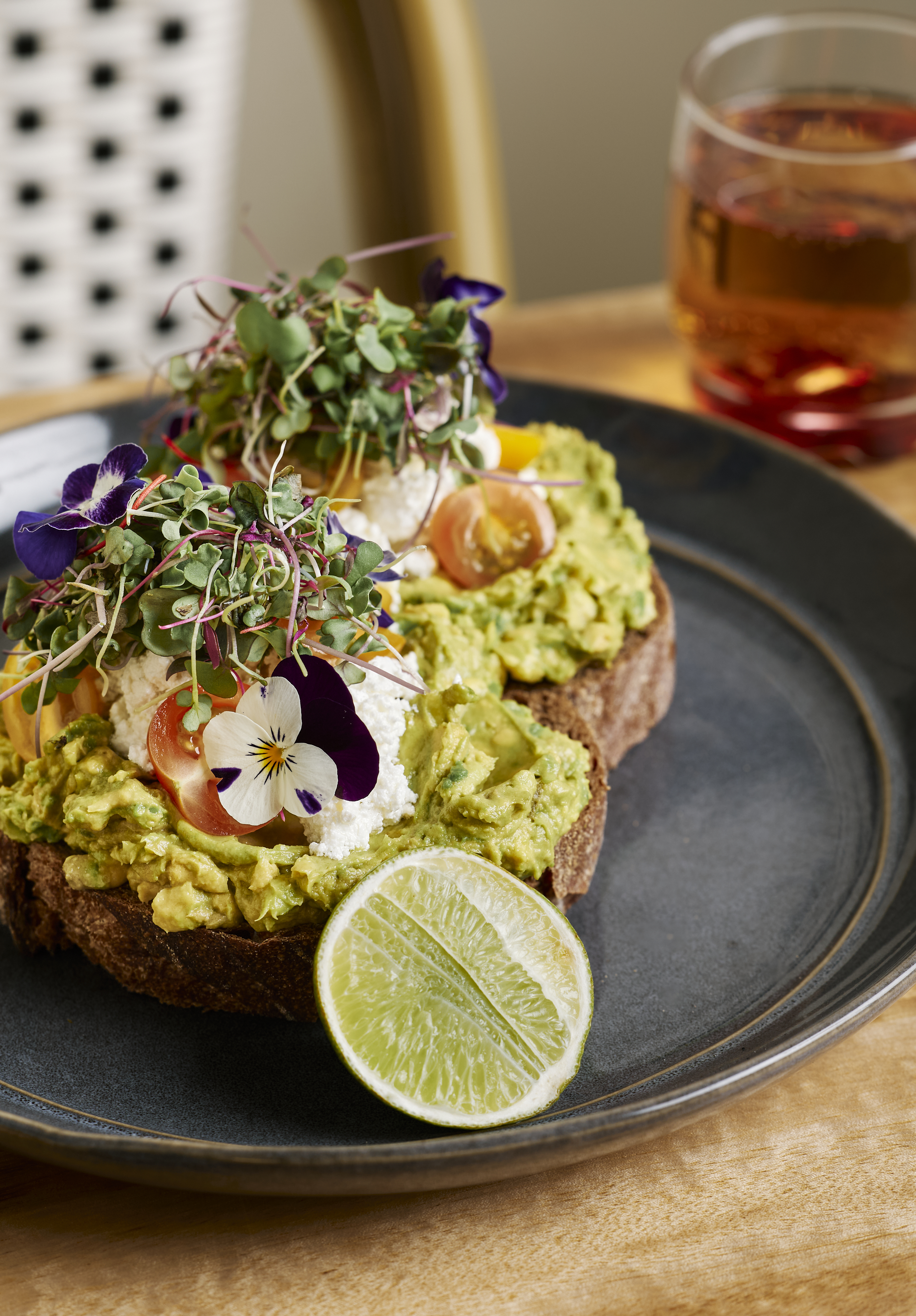 Smashed avocado on dark rye sourdough with edible flowers at Mickle Pickle